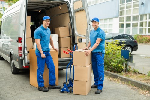 Movers carrying furniture through a Plumstead apartment entrance